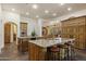 Open concept kitchen with a large island, granite countertop, and custom wood detailing at 7640 E Poinsettia Dr, Scottsdale, AZ 85260