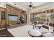 Cozy living room with a stone fireplace, large windows, and comfortable seating area at 7640 E Poinsettia Dr, Scottsdale, AZ 85260