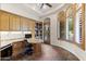 Bright home office featuring custom built-ins, a granite desk, and ample natural light at 7640 E Poinsettia Dr, Scottsdale, AZ 85260