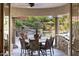 Covered outdoor dining area with views of the pool, rock waterfall and lavish landscaping at 7640 E Poinsettia Dr, Scottsdale, AZ 85260