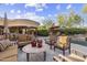 An outdoor patio area with desert landscaping, multiple seating arrangements, and fireplace at 7640 E Poinsettia Dr, Scottsdale, AZ 85260