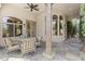 Inviting covered patio with stone flooring, elegant columns, and comfortable seating at 7640 E Poinsettia Dr, Scottsdale, AZ 85260