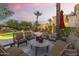 Outdoor patio with comfortable seating surrounding a stone table, overlooking a serene pool and lush backyard at 7640 E Poinsettia Dr, Scottsdale, AZ 85260
