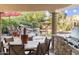 Outdoor living space with covered patio, stone fireplace, and lush landscaping surrounding the pool area at 7640 E Poinsettia Dr, Scottsdale, AZ 85260