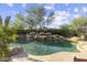 This backyard features a luxurious pool with rock waterfall feature and lush landscaping at 7640 E Poinsettia Dr, Scottsdale, AZ 85260