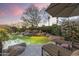 Backyard pool with rock waterfall feature, lush landscaping, lounge chairs, and serene ambiance at 7640 E Poinsettia Dr, Scottsdale, AZ 85260
