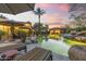 Outdoor living at dusk featuring a pool, lounge chairs, and a beautifully landscaped yard with desert vegetation at 7640 E Poinsettia Dr, Scottsdale, AZ 85260