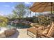 Relax poolside on lounge chairs near a rock waterfall and spa surrounded by lush landscaping at 7640 E Poinsettia Dr, Scottsdale, AZ 85260