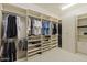 Spacious walk-in closet with custom shelving, and shoe racks for optimal organization at 7640 E Poinsettia Dr, Scottsdale, AZ 85260