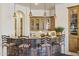 Stylish wet bar featuring stone accents, granite countertop, pendant lighting, and wooden cabinets at 7640 E Poinsettia Dr, Scottsdale, AZ 85260