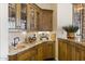 Well-appointed wet bar area with granite countertops, copper sink, and custom wood cabinetry at 7640 E Poinsettia Dr, Scottsdale, AZ 85260