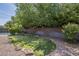 The backyard features gravel, artificial turf, mature shade trees and access to the pool area at 807 E San Remo Ave, Gilbert, AZ 85234