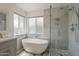 This modern bathroom boasts a soaking tub, a glass shower with tile surround and designer fixtures at 807 E San Remo Ave, Gilbert, AZ 85234