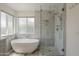 This renovated bathroom boasts a modern soaking tub, a glass shower with tile surround and designer fixtures at 807 E San Remo Ave, Gilbert, AZ 85234