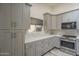 Well-lit kitchen featuring gray cabinetry, stainless steel appliances, and white marble countertops at 807 E San Remo Ave, Gilbert, AZ 85234
