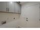This laundry room features a door to the garage, ample cabinet space and tile flooring at 807 E San Remo Ave, Gilbert, AZ 85234