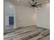 Bright living room with modern floors, white walls, a ceiling fan, and doors leading to other rooms at 807 E San Remo Ave, Gilbert, AZ 85234