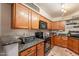 Well-equipped kitchen featuring granite countertops, wooden cabinets, and modern appliances at 8787 E Mountain View Rd # 1110, Scottsdale, AZ 85258