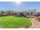 A spacious backyard boasting a lush lawn, covered patio, and relaxing hot tub, perfect for outdoor enjoyment at 9623 S 25Th Ln, Phoenix, AZ 85041