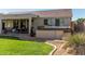 A pristine backyard features a covered patio, a well-maintained lawn, and an inviting hot tub at 9623 S 25Th Ln, Phoenix, AZ 85041