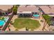 Aerial view of a private backyard featuring a pristine lawn, mature landscaping, and sparkling pool at 9623 S 25Th Ln, Phoenix, AZ 85041