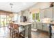 Bright kitchen with stone countertops, modern appliances, a breakfast bar, and a dining area at 9623 S 25Th Ln, Phoenix, AZ 85041