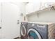 Practical laundry area with modern washer, dryer, and overhead cabinets for storage and organization at 9623 S 25Th Ln, Phoenix, AZ 85041