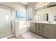 Inviting bathroom boasts a shower, soaking tub, glass block window, and double sink vanity at 9623 S 25Th Ln, Phoenix, AZ 85041