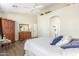 Comfortable main bedroom features wood-look floors, ceiling fan, and adjacent arched doorway at 9623 S 25Th Ln, Phoenix, AZ 85041