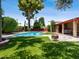 Lush backyard showcasing a sparkling pool, well-manicured turf, and a cozy fire pit area for outdoor enjoyment at 1 W Canterbury Ln, Phoenix, AZ 85023
