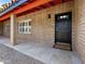 Inviting covered front porch with stone pavers, accent column, and a welcoming black door at 1 W Canterbury Ln, Phoenix, AZ 85023