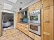 Open concept kitchen featuring stainless steel double ovens, natural cabinets, and modern design at 1 W Canterbury Ln, Phoenix, AZ 85023