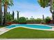 Private backyard pool surrounded by manicured landscaping and turf, creating a serene oasis for swimming and relaxation at 1 W Canterbury Ln, Phoenix, AZ 85023