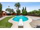 Sparkling backyard pool with a diving board, framed by mature trees and lush landscaping for ultimate privacy at 1 W Canterbury Ln, Phoenix, AZ 85023