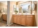 Bathroom featuring double sinks with light wood cabinetry and a spacious vanity area at 10136 E Isleta Ave, Mesa, AZ 85209
