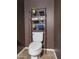 Well-organized bathroom featuring a toilet with an over-the-toilet storage rack with decorative towels and plants at 10136 E Isleta Ave, Mesa, AZ 85209