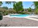 Community pool area with ample lounge seating, manicured landscaping, and nearby residential buildings, perfect for relaxation at 10136 E Isleta Ave, Mesa, AZ 85209