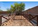 Backyard area featuring a garden area with a wooden frame for climbing plants and desert landscaping at 10235 E Jerome Ave, Mesa, AZ 85209