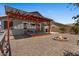 Backyard view of a covered patio with solar panels, a fire pit, and desert landscaping at 10235 E Jerome Ave, Mesa, AZ 85209