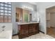Bathroom featuring a dual sink vanity, framed mirror, glass block window, tub and walk-in shower at 10235 E Jerome Ave, Mesa, AZ 85209