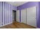 Bedroom featuring striped accent wall, neutral trim and carpet and sliding door closet at 10235 E Jerome Ave, Mesa, AZ 85209
