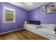bedroom featuring purple walls, hardwood floors, a window, and a built-in bench with storage at 10235 E Jerome Ave, Mesa, AZ 85209
