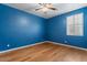 Bright bedroom features a ceiling fan, wood floors, and window with natural light at 10235 E Jerome Ave, Mesa, AZ 85209