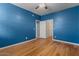 Bright bedroom features a ceiling fan, wood floors, and an entry door at 10235 E Jerome Ave, Mesa, AZ 85209