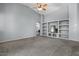 Spacious living room featuring vaulted ceilings, a ceiling fan and built-in shelving at 10235 E Jerome Ave, Mesa, AZ 85209