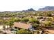 Aerial view of a neighborhood with a pool and mountain range in the background at 10523 E Sleepy Hollow Trl, Gold Canyon, AZ 85118