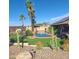 Lush backyard oasis with pool, palm trees, green turf and barbecue at 10523 E Sleepy Hollow Trl, Gold Canyon, AZ 85118