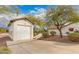 Detached garage and home exterior with desert landscaping, and a clean driveway leading to the property at 10523 E Sleepy Hollow Trl, Gold Canyon, AZ 85118