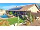 Rear of the home with solar panels, swimming pool and manicured landscaping at 10523 E Sleepy Hollow Trl, Gold Canyon, AZ 85118