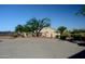 Home featuring mature trees and bushes behind a tall masonry wall at 10523 E Sleepy Hollow Trl, Gold Canyon, AZ 85118